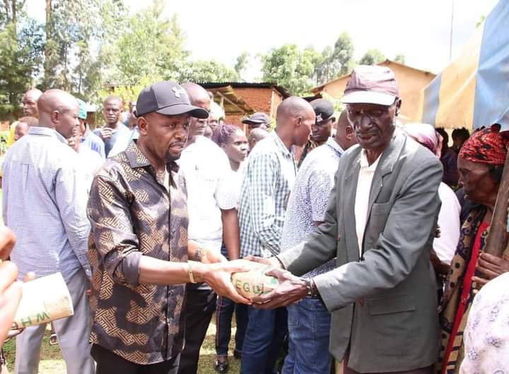 Natembeya gives out a packet of maize seeds to one of the vulnerable farmers in Trans Nzoia.