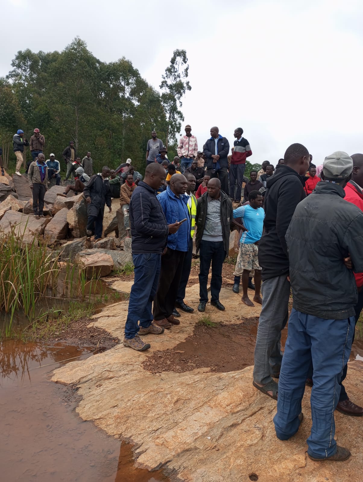 Locals around the dam where the body was retrieved.