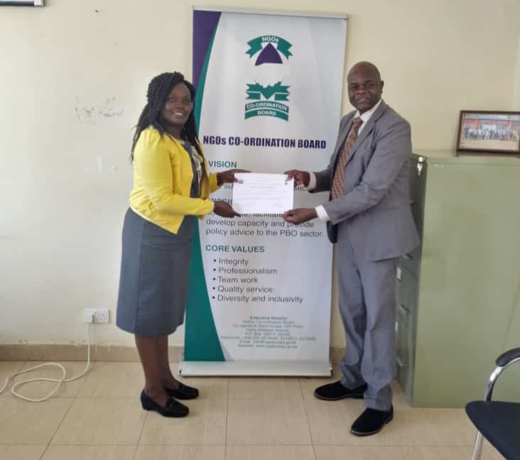 William Getumbe receiving registration certificate from NGO Coordination Board North Rift regional manager Caroline Kimaiyo on May 10, 2023.