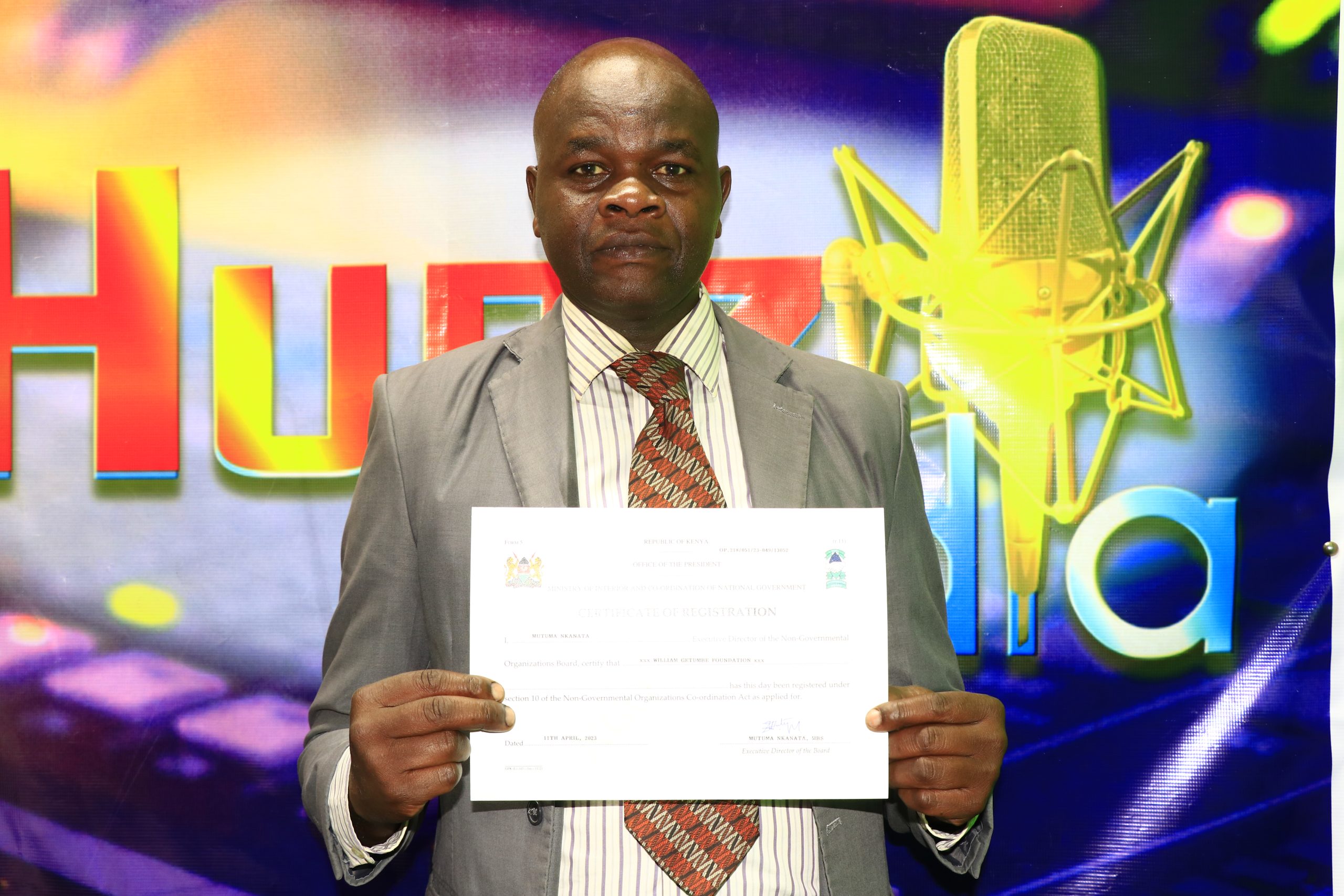 Getumbe with the foundation's registration certificate. 