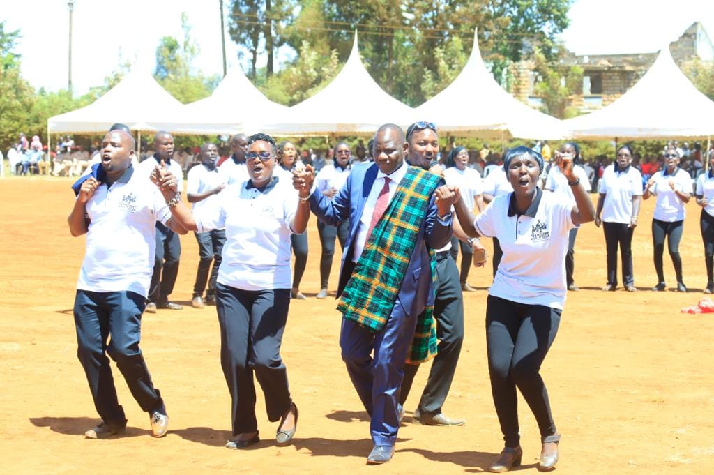 Govenror Bii joins choirs fr a dance duirng Madaraka Day celenrations at Ainaptich Primary School.