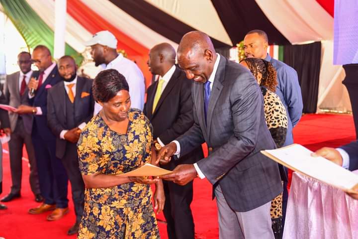 President Ruto hands over a title deed to one of the Embakasi locals.