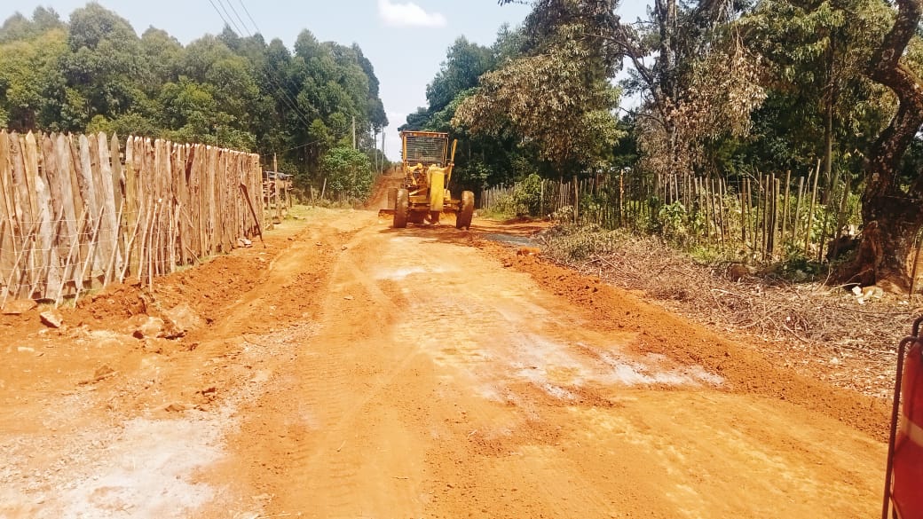 A County grader at work along St. Georges -Kamoson road in Kapseret Ward.