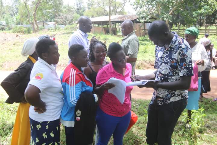 A county officials vets documents of locals seeking to be included in the Elimu Fund.