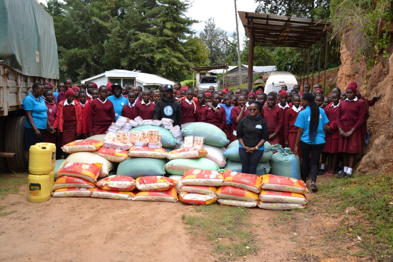 Students pose for a photo with officials from the Child Welfare Society after delivering the food donations.