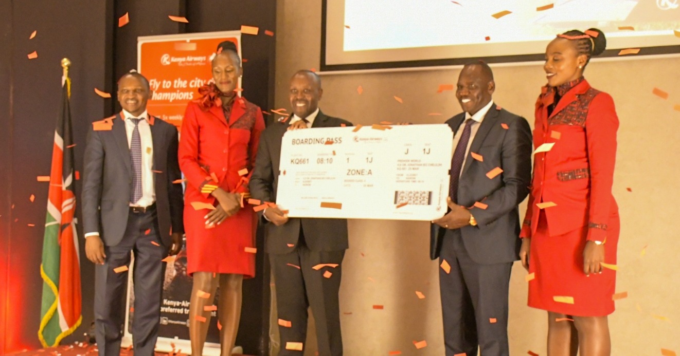 Governor Bii is given a boarding pass to be one of the passengers marking the return of Kenya Airways flights to Eldoret International Airport. Photo/KAA.