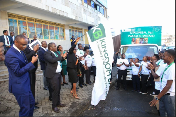Kingdom Bank Board Chair Margaret Karangatha accompanied by bank staff flags off a market activation roadshow during the grand opening of the banks 20th branch in Gikomba