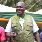 Uasin Gishu Agriculture Executive Edward Sawe with a coffee seedling.