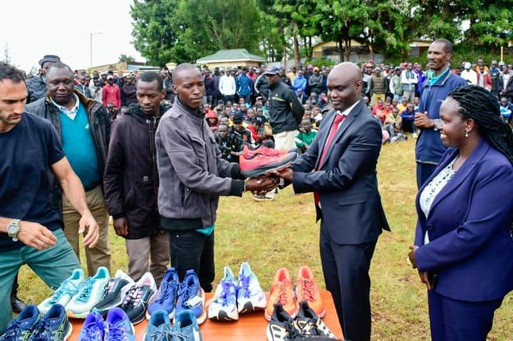 Governor Rotich giving an athlete a pair of shoes
