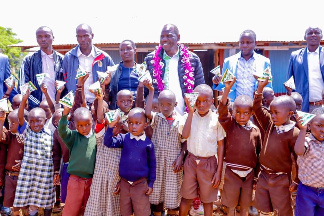 Bii with ECDE pupils holding milk 