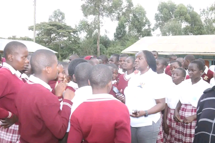 Trans Nzoia County Secretary Truphosa Amere chats with Muungano Secondary School learners 