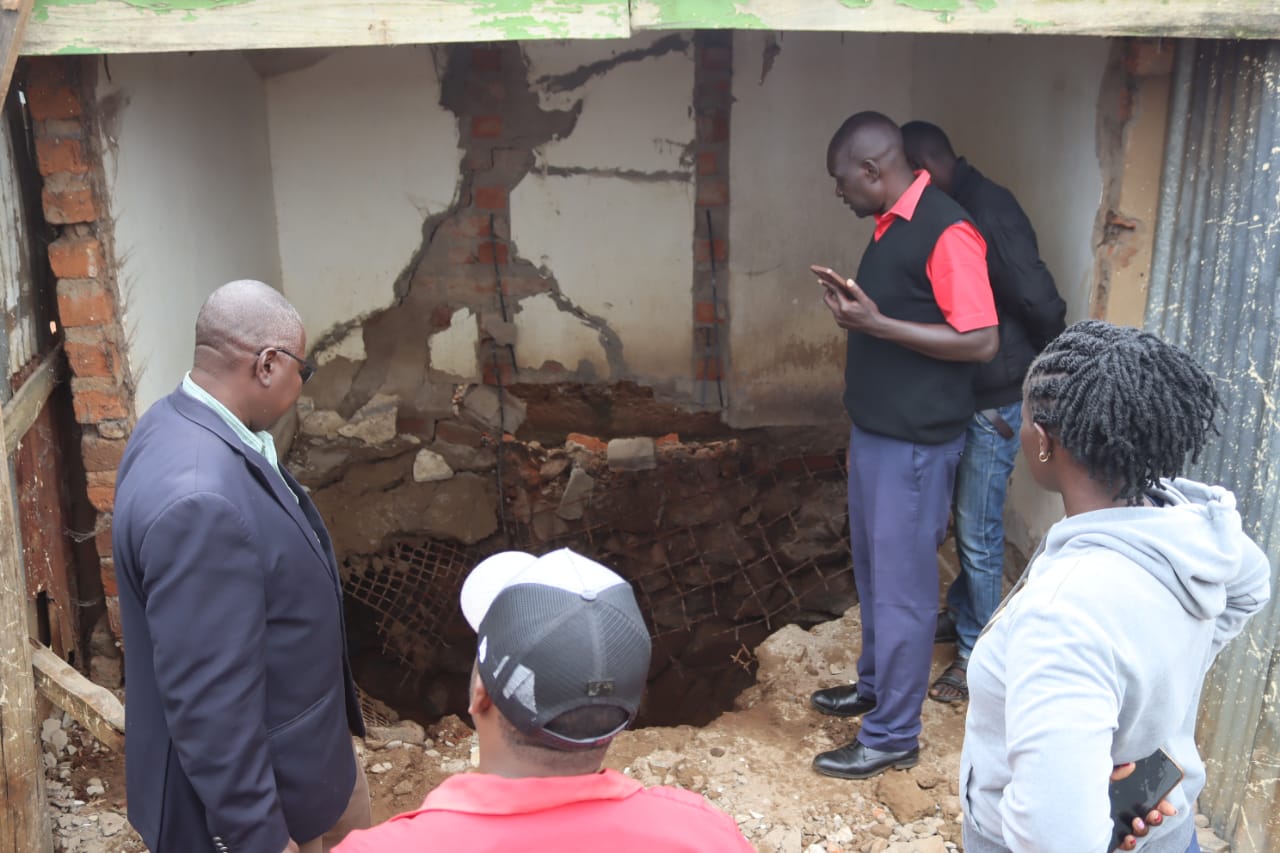 People standing next to a collapsed pit latrine in Eldoret 