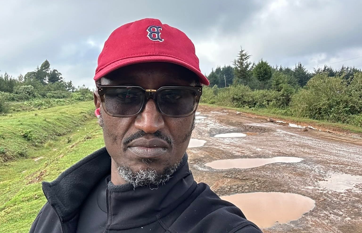 Businessman Buzeki takes a selfie on a dilapidated road in Ainabkoi Sub-County 