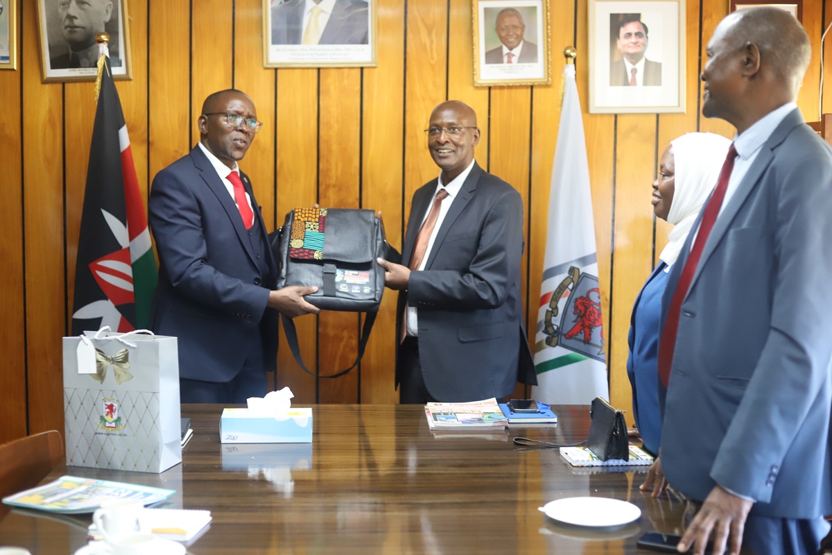 Egerton University Deputy Vice Chancellor, Administration, Finance and Planning, Prof. George Muthaa, presents a gift to the Institution of Engineers of Kenya (IEK) delegation during its courtesy visit to the University.